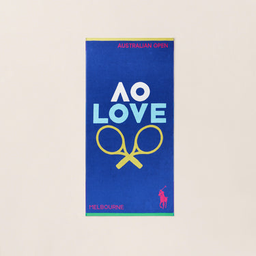 Navy towel with 'AO Love' and tennis racket design, bright pink iconic Polo Ralph Lauren logo on a beige background