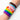 A multicolored wristband worn by a person with the AO logo on the wristband, featuring a rainbow design on a white background.