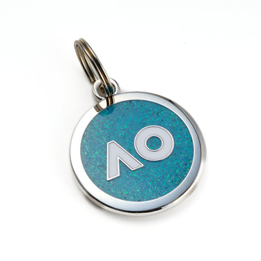 A round blue pet tag with the AO logo in white with silver edge, attached to a keyring, on a white background.